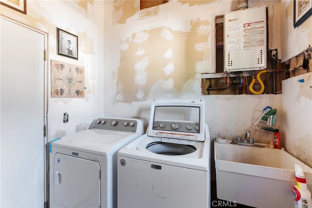 washroom featuring separate washer and dryer, water heater, and sink