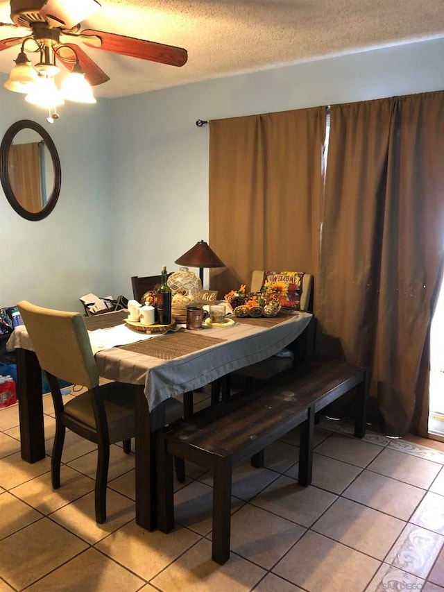 tiled dining room featuring ceiling fan and a textured ceiling