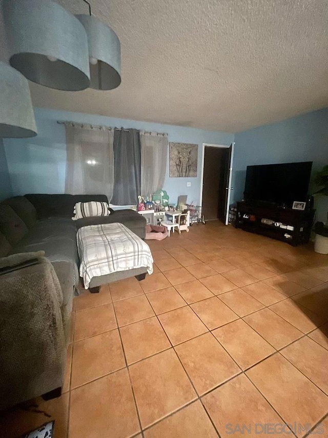 tiled living room featuring a textured ceiling