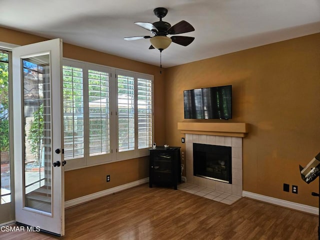 interior space with a fireplace, ceiling fan, and hardwood / wood-style flooring