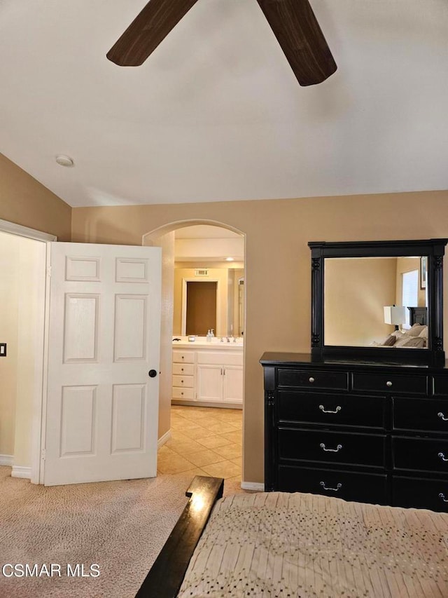 tiled bedroom featuring ceiling fan and ensuite bathroom