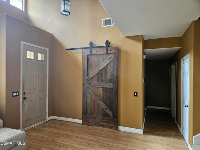 foyer featuring light wood-type flooring and a barn door