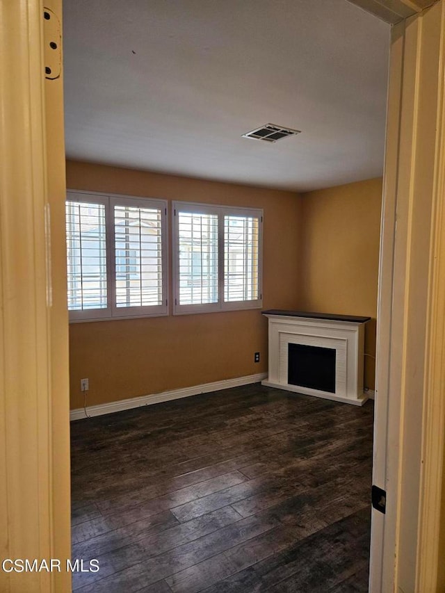 unfurnished living room with dark wood-type flooring