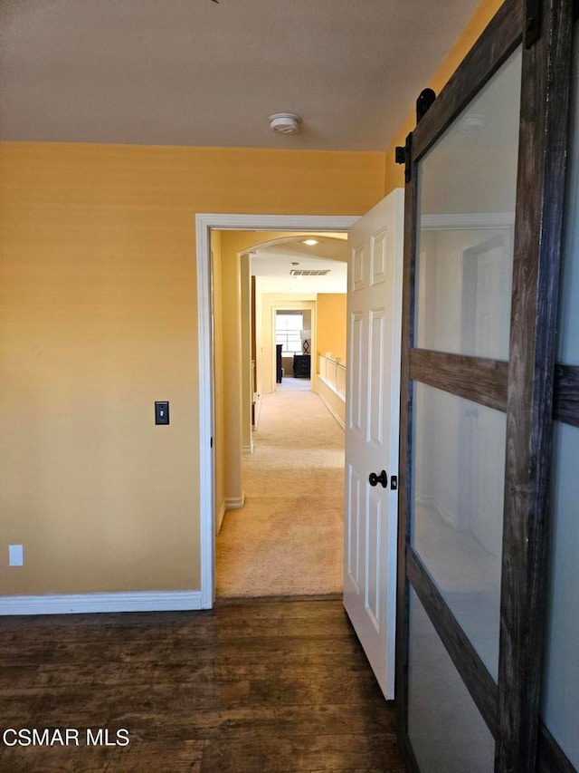 hallway with hardwood / wood-style floors and a barn door