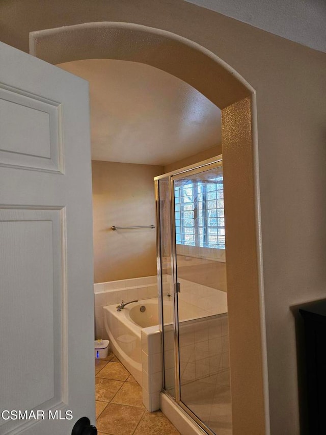 bathroom with tile patterned flooring and separate shower and tub