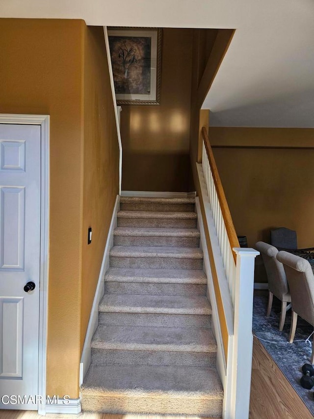 staircase with hardwood / wood-style floors