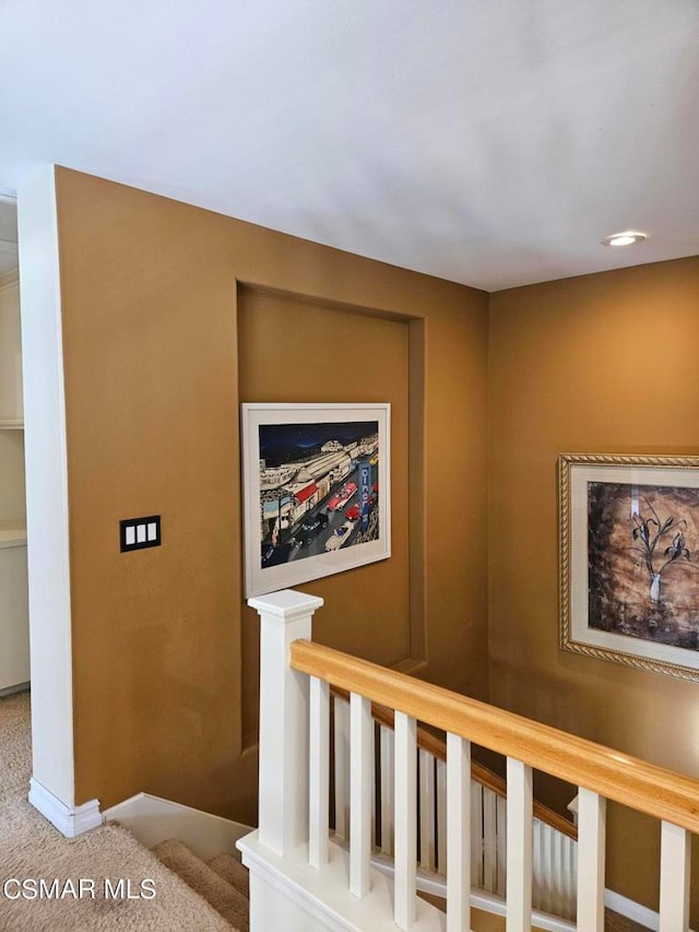 stairway featuring carpet flooring