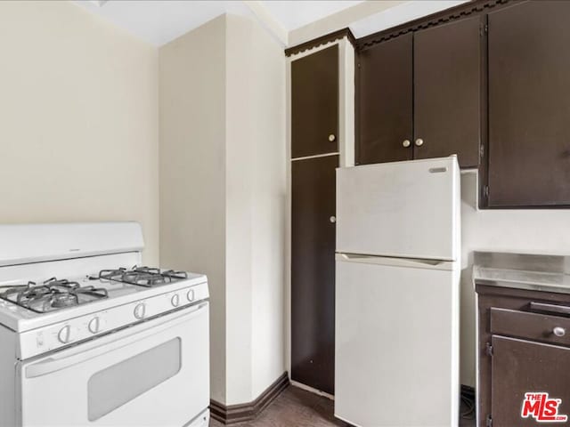 kitchen featuring dark brown cabinets and white appliances