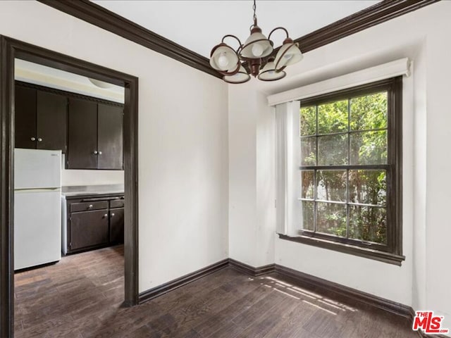 unfurnished dining area with ornamental molding, dark hardwood / wood-style floors, and a notable chandelier