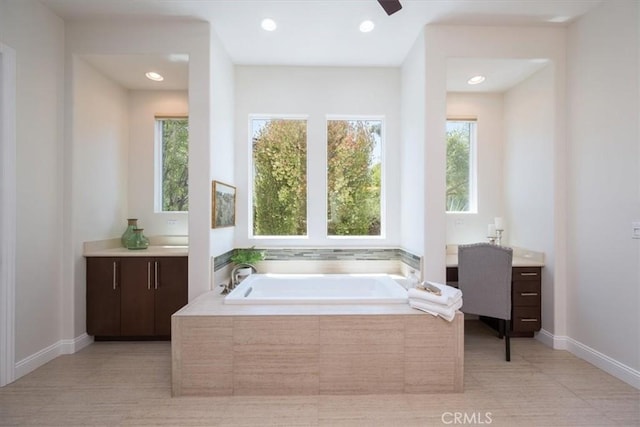 full bathroom with baseboards, ceiling fan, a garden tub, vanity, and recessed lighting