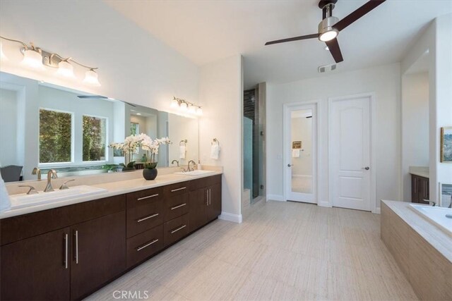 bathroom with visible vents, a sink, a shower stall, and double vanity