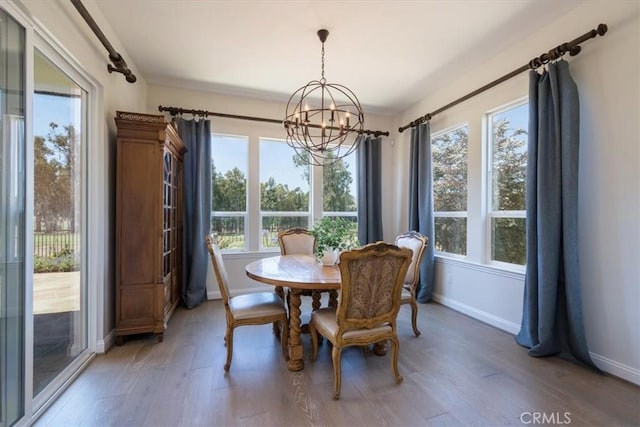 dining room with a chandelier, light wood finished floors, and baseboards