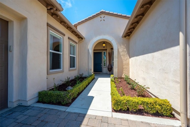 entrance to property featuring stucco siding