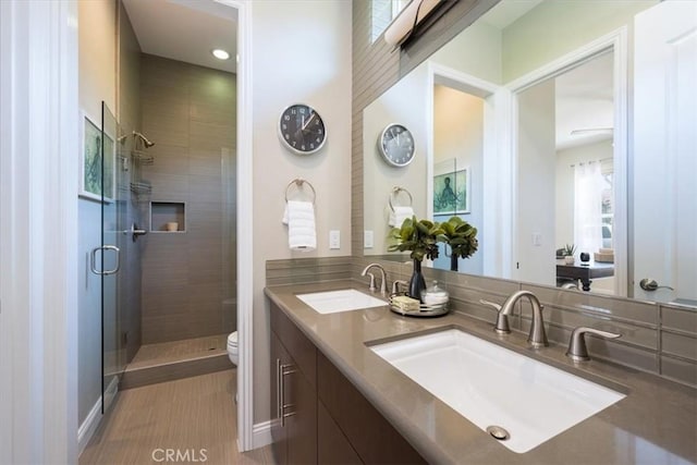 full bathroom featuring a stall shower, a sink, and toilet