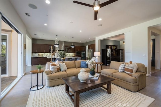 living area with light wood-style floors, visible vents, a ceiling fan, and recessed lighting