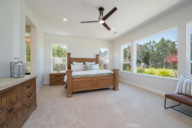 bedroom with light colored carpet, baseboards, and multiple windows