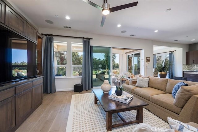 living room with a ceiling fan, light wood-type flooring, visible vents, and recessed lighting