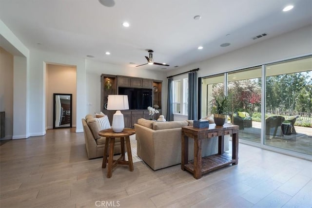 living room featuring ceiling fan, light wood-style flooring, recessed lighting, visible vents, and baseboards