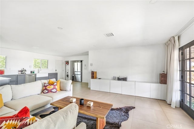 living room featuring sink and light tile patterned floors