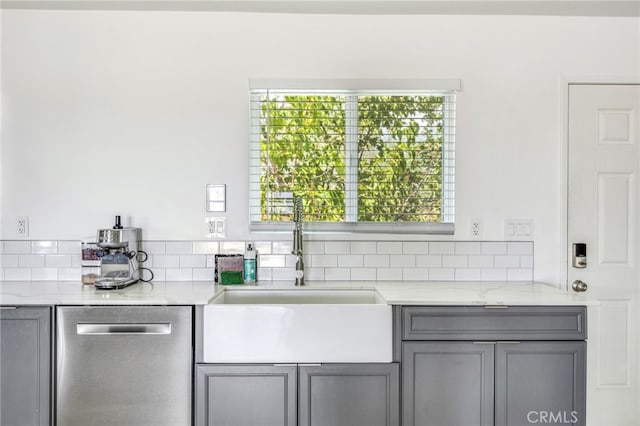 kitchen featuring gray cabinetry, light stone countertops, sink, and stainless steel dishwasher