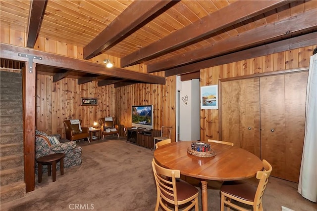 dining space with carpet, wood ceiling, beam ceiling, and wooden walls