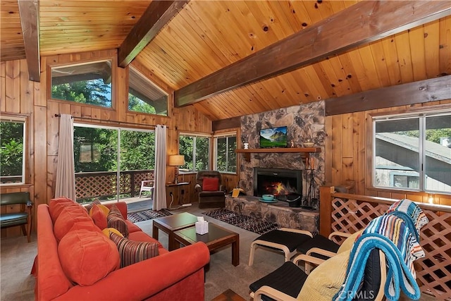 living room with plenty of natural light, beam ceiling, wood walls, and a stone fireplace