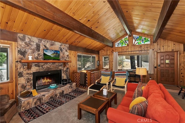 carpeted living room featuring vaulted ceiling with beams, a fireplace, and wooden walls