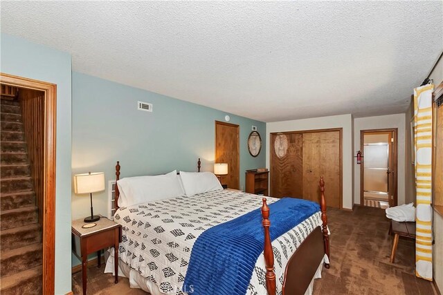 carpeted bedroom with a textured ceiling and a closet