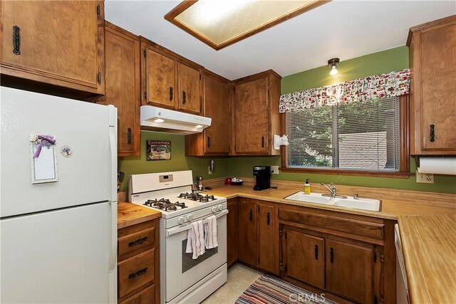 kitchen featuring sink, butcher block counters, and white appliances