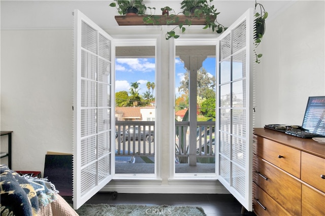 doorway to outside with ornamental molding and dark hardwood / wood-style flooring