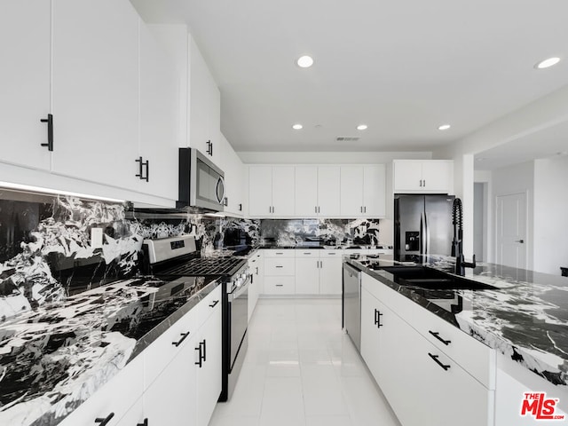 kitchen featuring stainless steel appliances, backsplash, sink, and white cabinetry