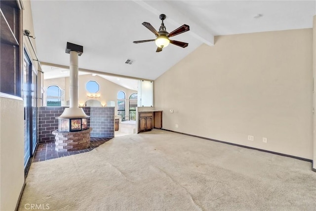 living room with a wood stove, ceiling fan, vaulted ceiling with beams, and dark colored carpet