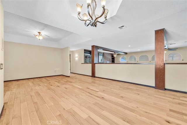 unfurnished living room with a chandelier and light hardwood / wood-style floors