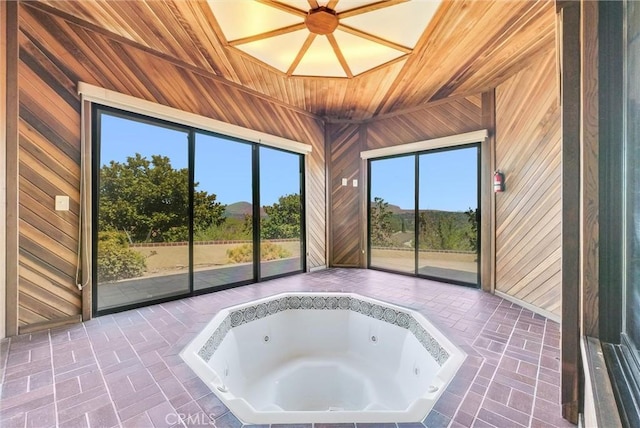 unfurnished sunroom with a jacuzzi and vaulted ceiling