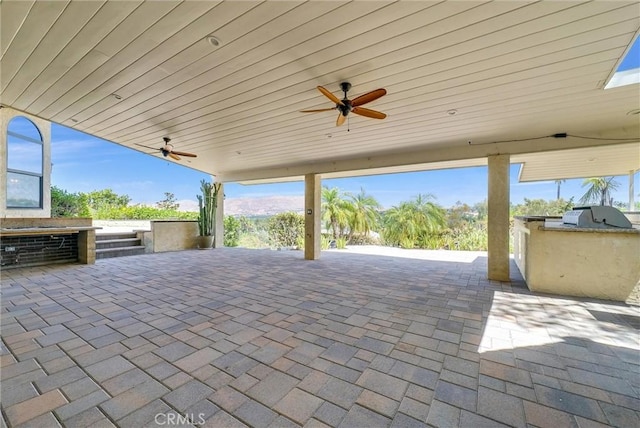 view of patio featuring ceiling fan, exterior kitchen, and grilling area