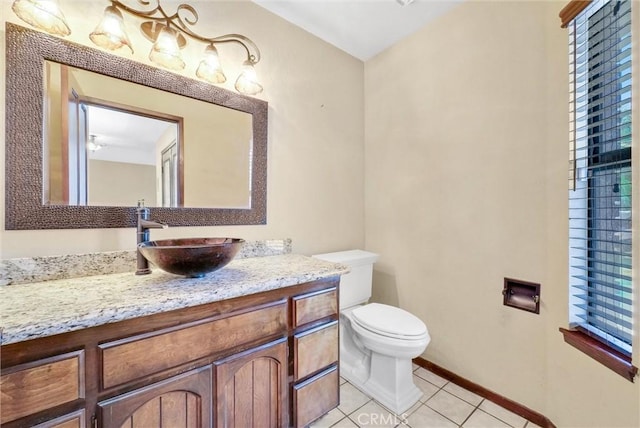 bathroom with toilet, vanity, and tile patterned floors