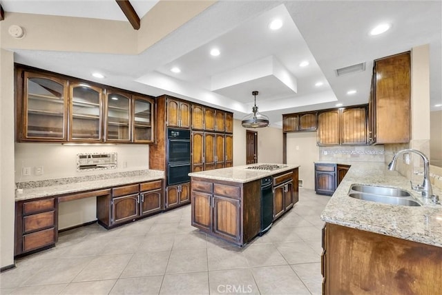 kitchen featuring a tray ceiling, sink, a center island, and pendant lighting