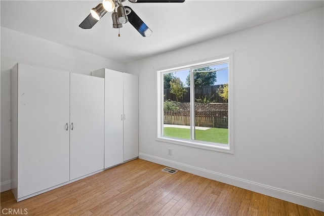 unfurnished bedroom with ceiling fan, light hardwood / wood-style flooring, and a closet