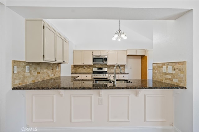 kitchen featuring decorative light fixtures, dark stone counters, stainless steel appliances, and decorative backsplash