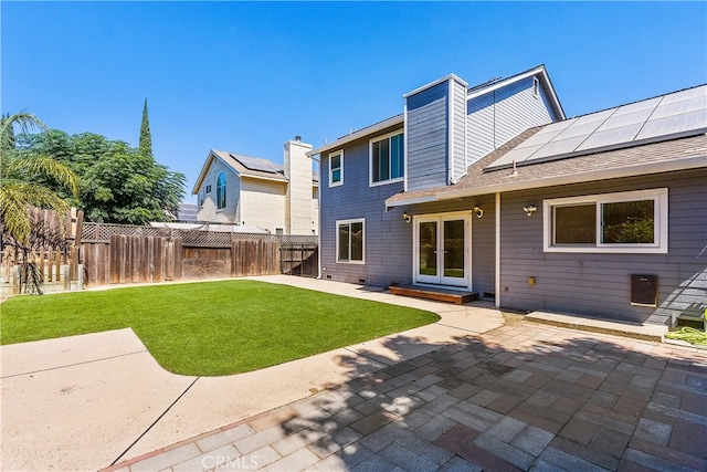 back of house featuring solar panels, a yard, and a patio