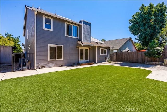 rear view of property featuring a patio area and a yard