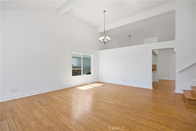 unfurnished room with beamed ceiling, an inviting chandelier, light hardwood / wood-style flooring, and high vaulted ceiling