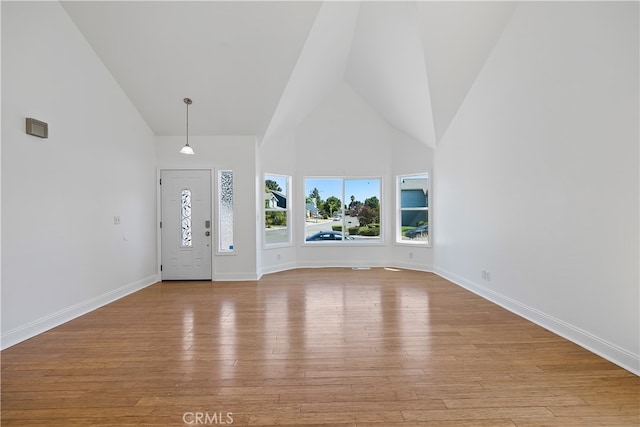 entrance foyer with light wood-type flooring and high vaulted ceiling