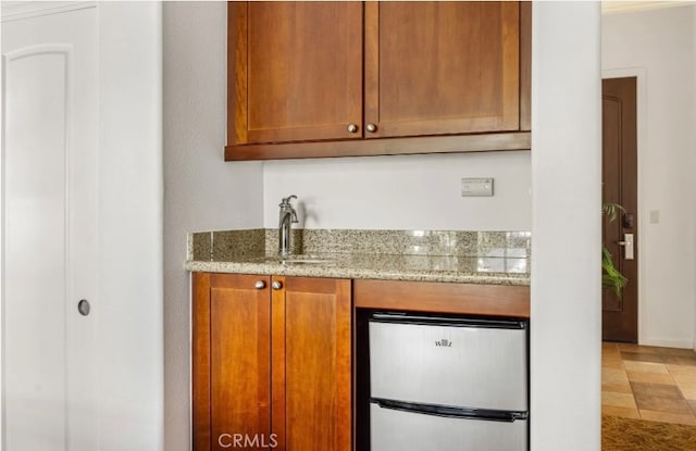 kitchen with stainless steel refrigerator and light stone counters