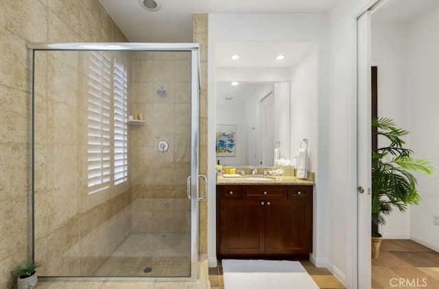 bathroom with a shower with door and vanity