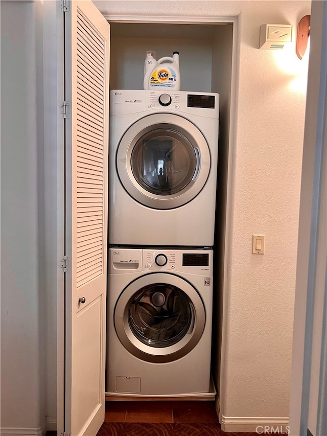 clothes washing area featuring stacked washing maching and dryer