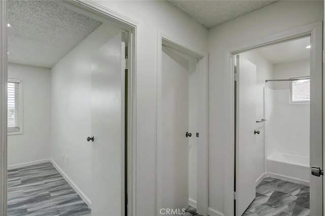 hallway featuring a textured ceiling and a healthy amount of sunlight