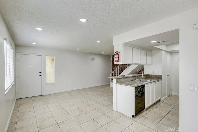 kitchen featuring white cabinets, dishwasher, sink, and a textured ceiling