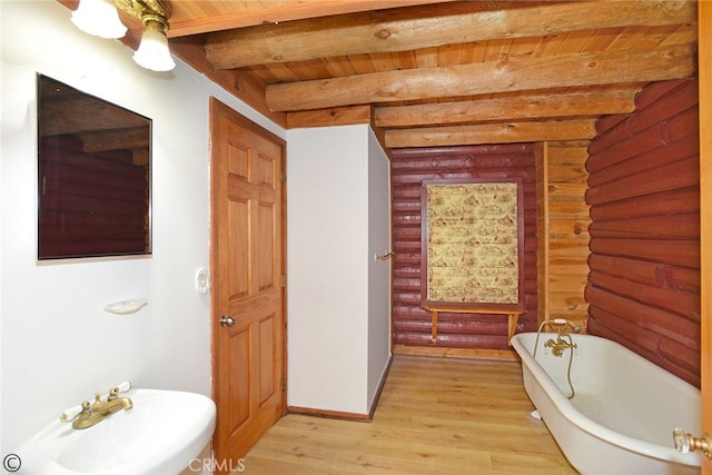 bathroom featuring hardwood / wood-style flooring, rustic walls, a tub to relax in, beam ceiling, and wood ceiling