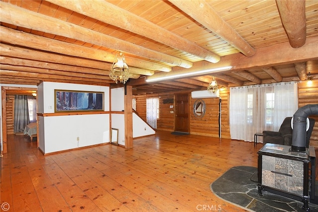 unfurnished living room with a wall unit AC, hardwood / wood-style flooring, wooden ceiling, beamed ceiling, and a wood stove